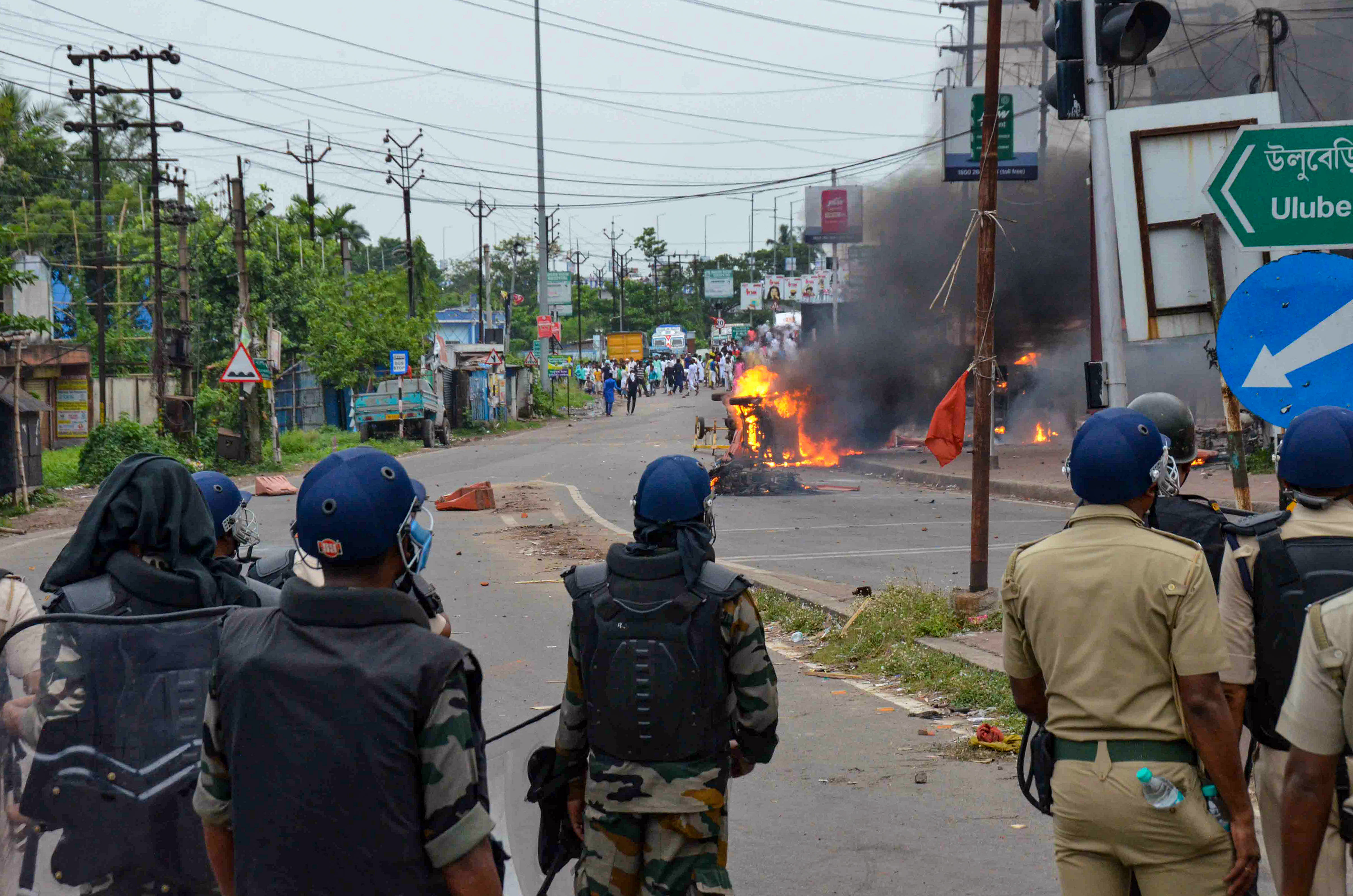 Security personnel try to maintain law and order as a vehicle is allegedly set ablaze by miscreants during a protest over controversial remarks made by two now-suspended BJP leaders about Prophet Mohammed. Credit: PTI Photo