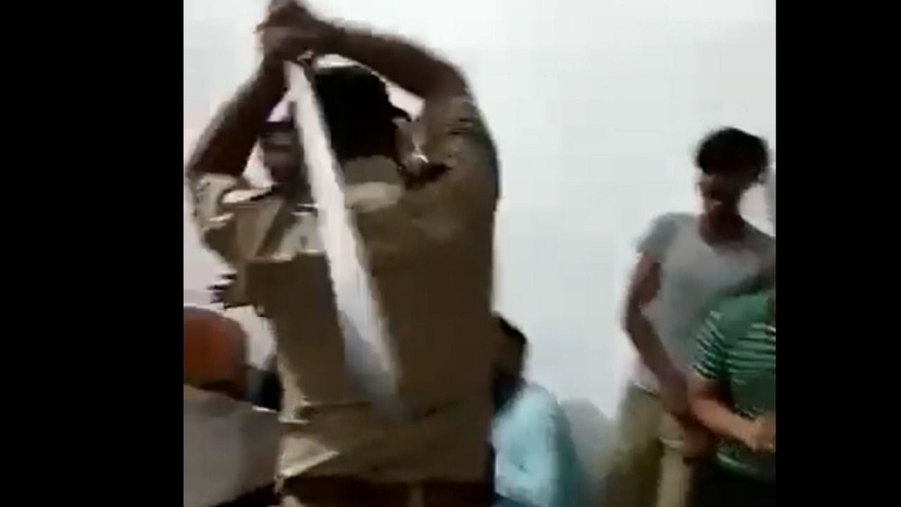 Screengrab of the viral video shows cop thrashing men with sticks. Credit; Twitter/@yadavakhilesh