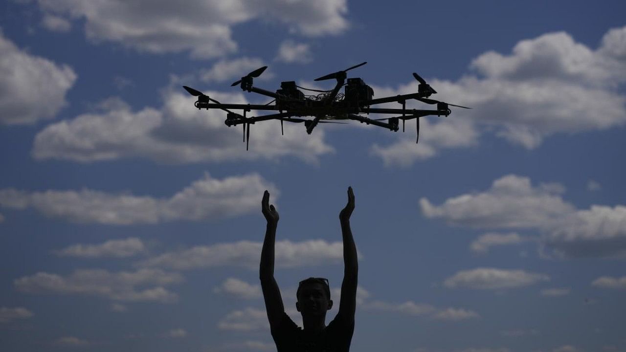 As Russian tanks and trucks rumbled close to their village, a Ukrainian teenager and his father stealthily launched their small drone into the air. Credit: AP Photo