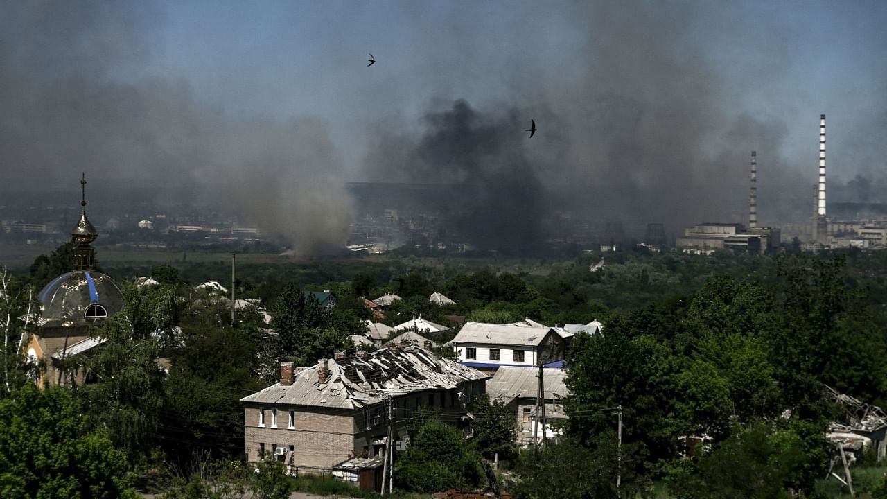  damaged building is pictured in Lysychansk as black smoke and dirt rise from the nearby city of Severodonetsk during battle between Russian and Ukrainian troops in the eastern Ukraine region of Donbas. Credit: AFP Photo