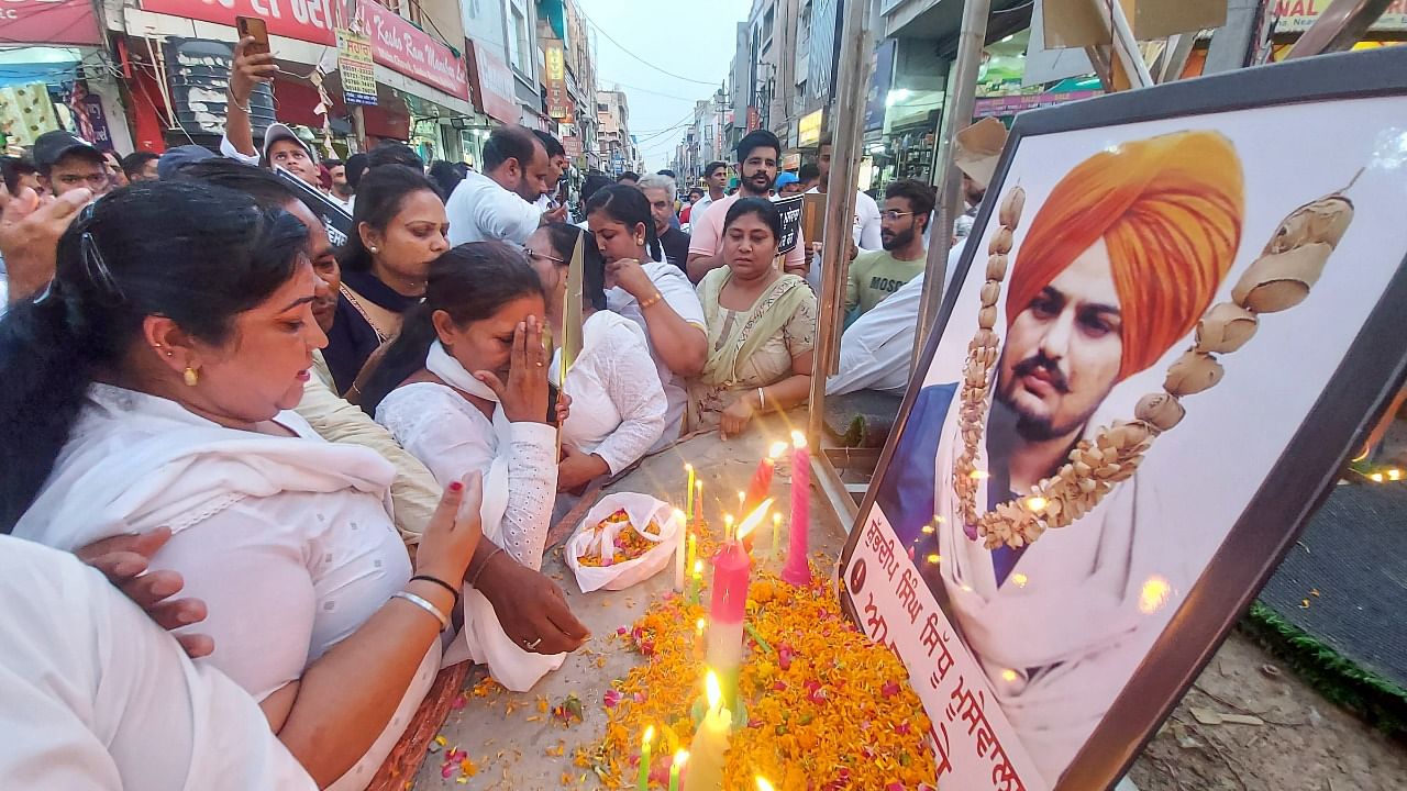 Workers light candles and pay floral tribute to late Punjabi singer and Congress leader Sidhu Moosewala. Credit: PTI Photo