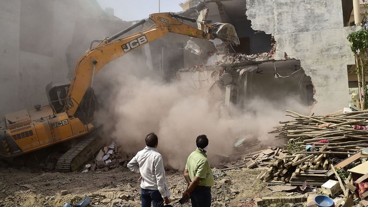 A bulldozer is being used to demolish the illegal structures of the residence of Javed Ahmed, a local leader who was allegedly involved in the recent violent protests against Bharatiya Janata Party. Credit: AFP Photo
