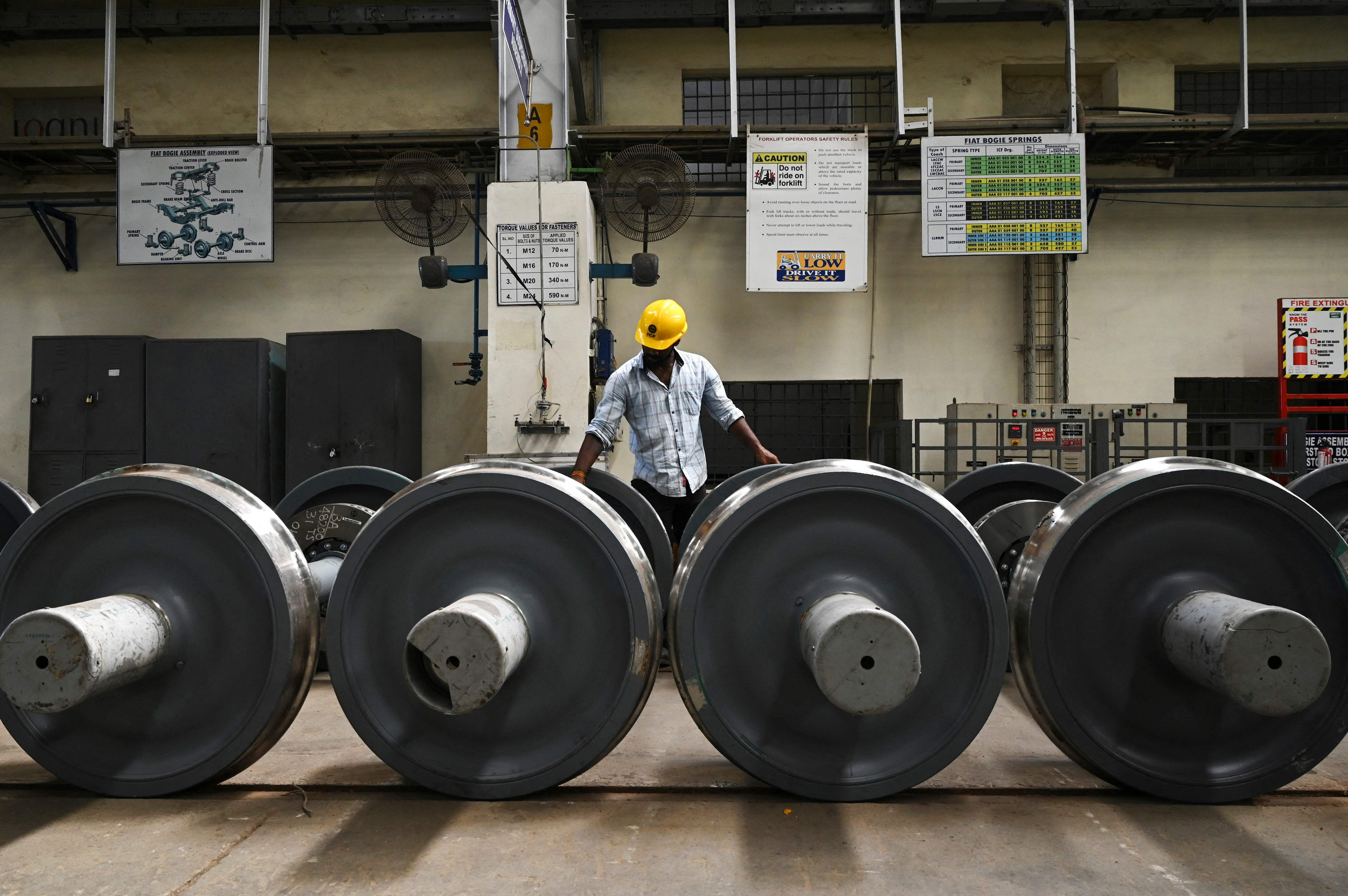 A worker checks wheel sets at the Integral Coach Factory in Chennai. Credit: AFP Photo