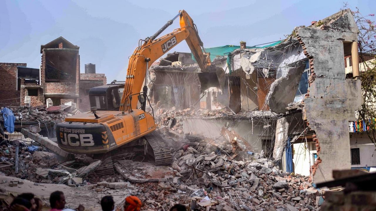 Bulldozer being used to demolish the 'illegally constructed' residence of Javed Ahmed, a local leader who was allegedly the key conspirator of violent protests against now-suspended BJP leaders' remarks on Prophet Muhammad, in Prayagraj, Sunday, June 12, 2022. Credit: PTI Photo