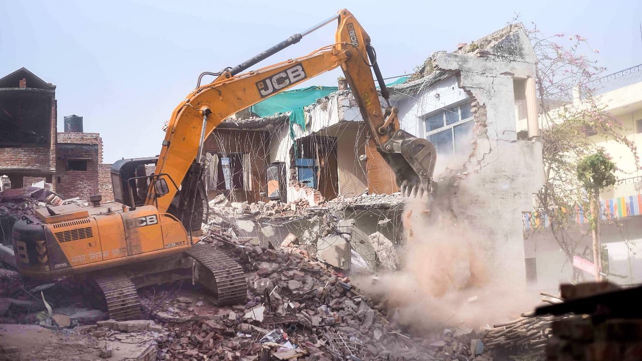 Bulldozer being used to demolish the 'illegally constructed' residence of Javed Ahmad who was allegedly the key conspirator of violent protests against now-suspended BJP leaders' remarks on Prophet Mohammed, in Prayagraj. Credit: PTI Photo