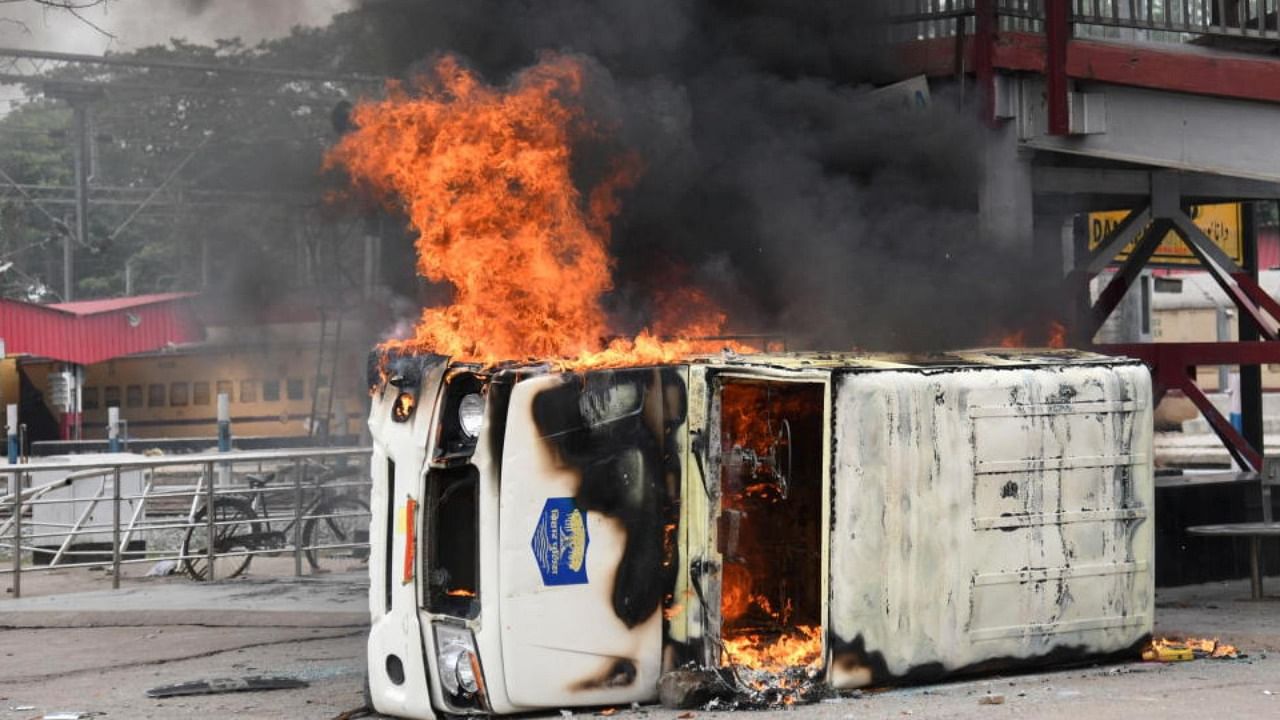 A police vehicle burns after it was set on fire by the protestors during a protest against "Agnipath scheme" for recruiting personnel for armed forces, in Patna, in the eastern state of Bihar, India, June 17, 2022. Credit: Reuters Photo