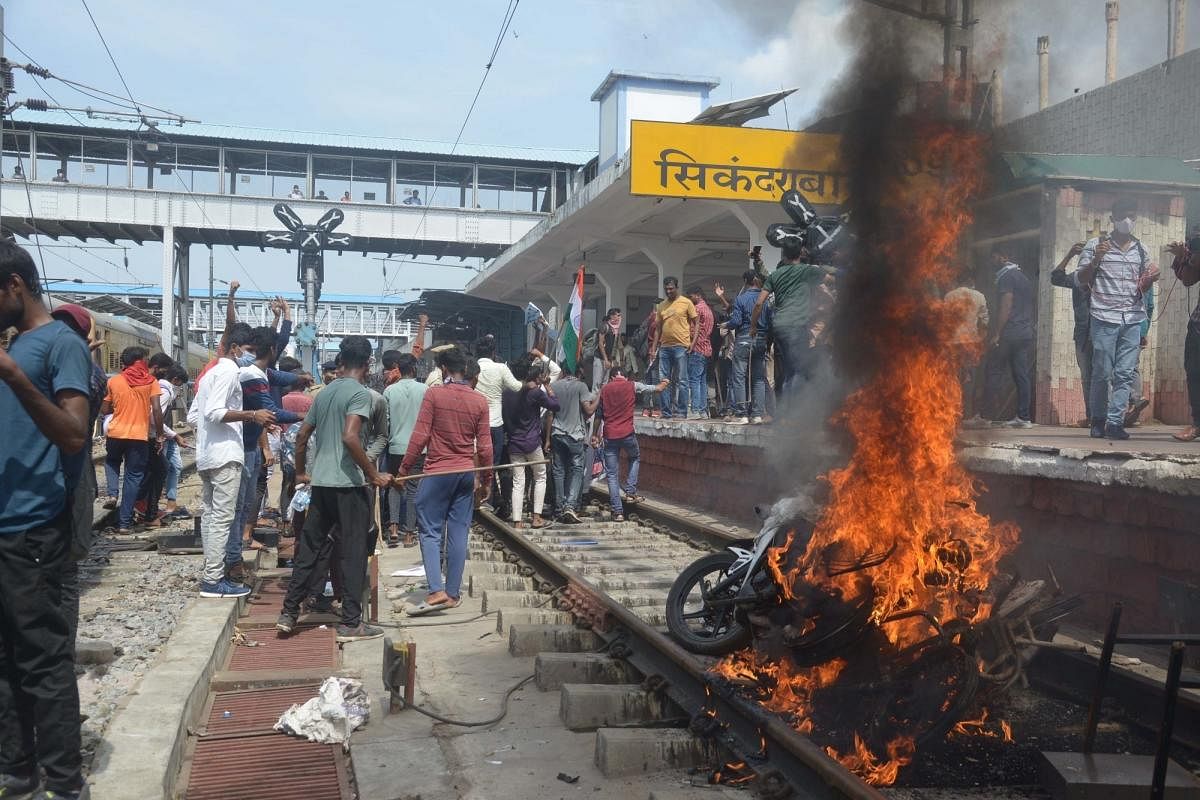 Protesters set ablaze a two-wheeler during a protest against Agnipath Recruitment Scheme, at Secunderabad railway station in Secunderabad. Credit: IANS Photo