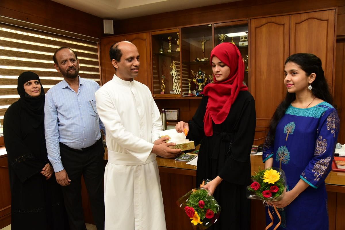 Ilham and Anisha Mallya share their joy with St Aloysius PU College Principal Rev Fr Clifford Sequeira in Mangaluru.