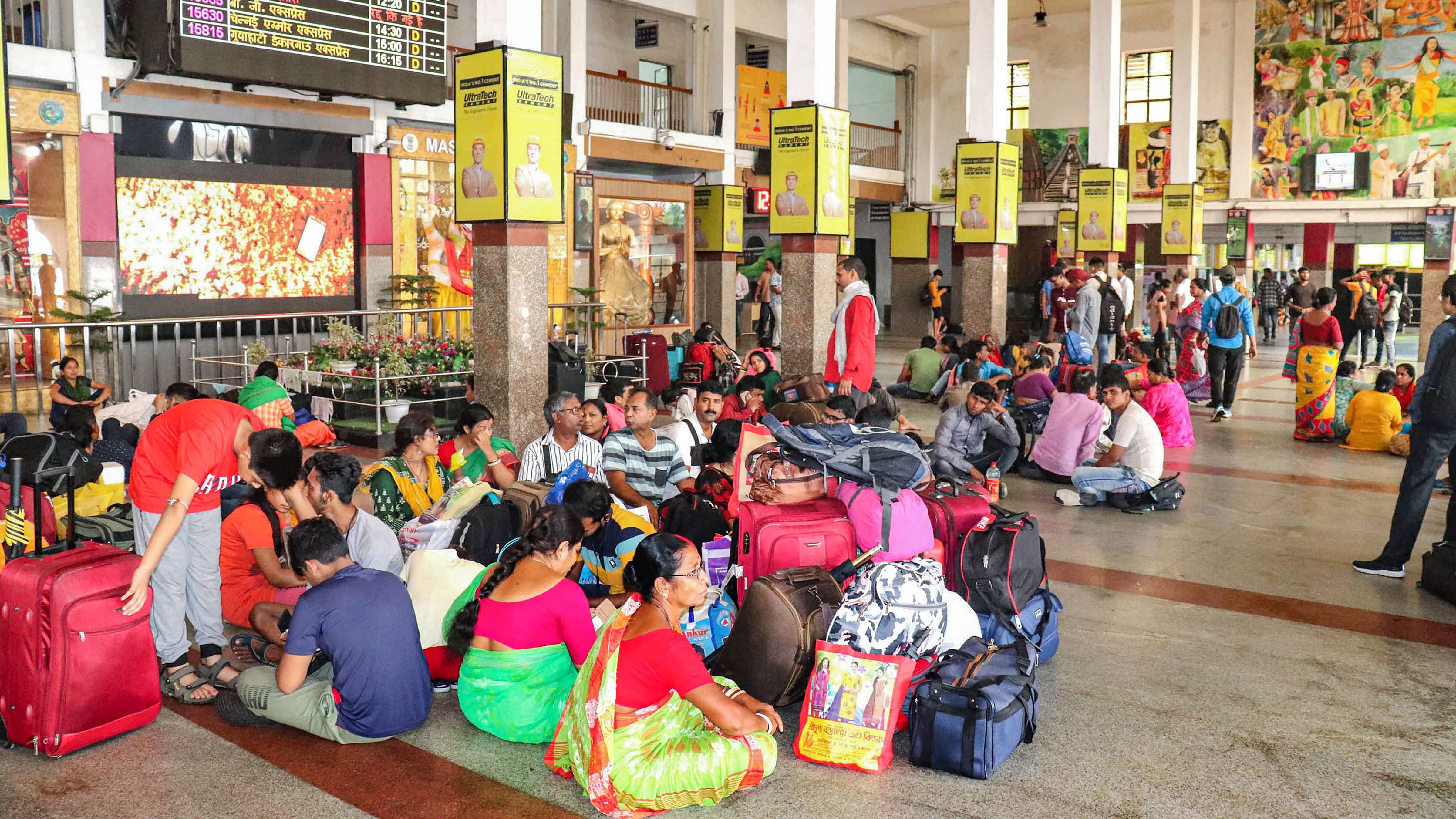 Passengers wait after several trains got cancelled due to protests against Centre's 'Agnipath' scheme and flooding of tracks following heavy rainfall. Credit: PTI Photo