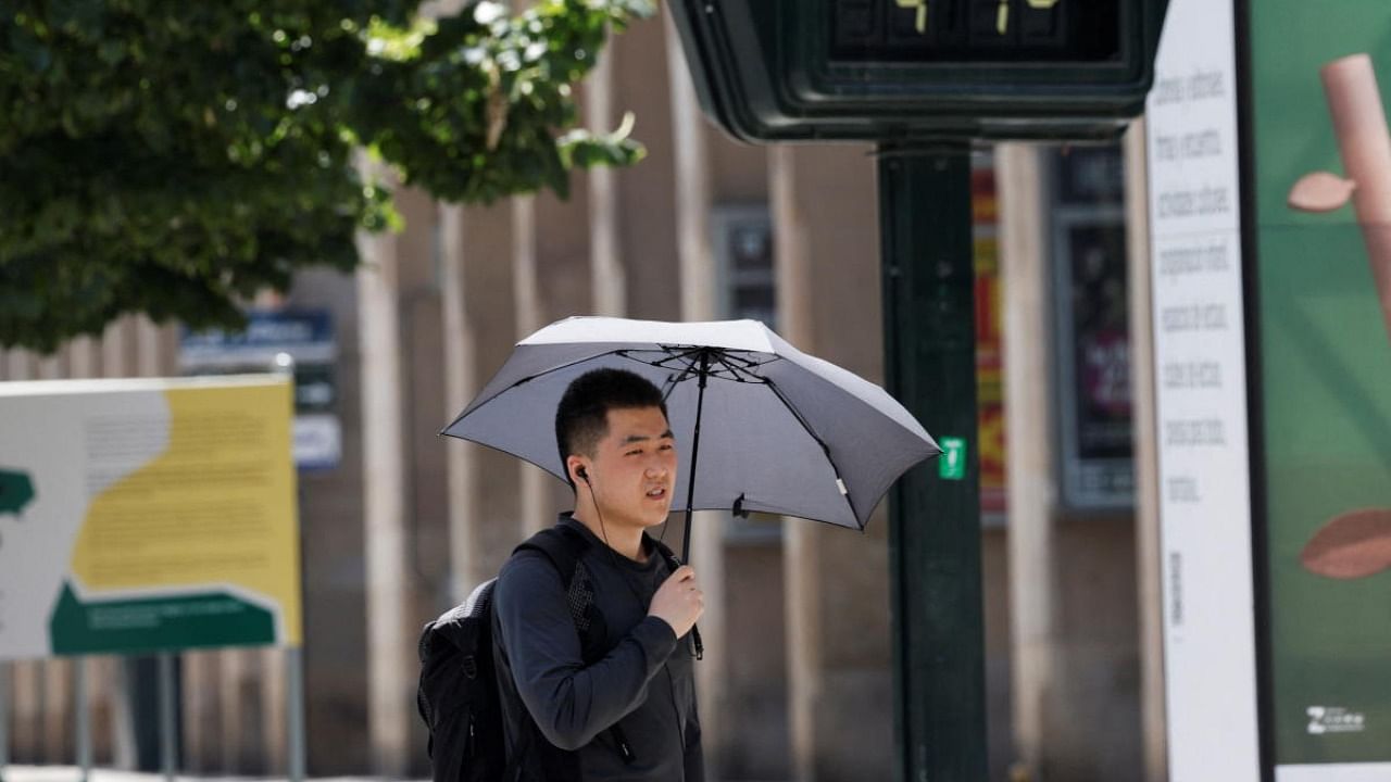 A man uses an umbrella to protect himself from the sun as high temperatures continue to affect the country, in Zaragoza. Credit: Reuters photo