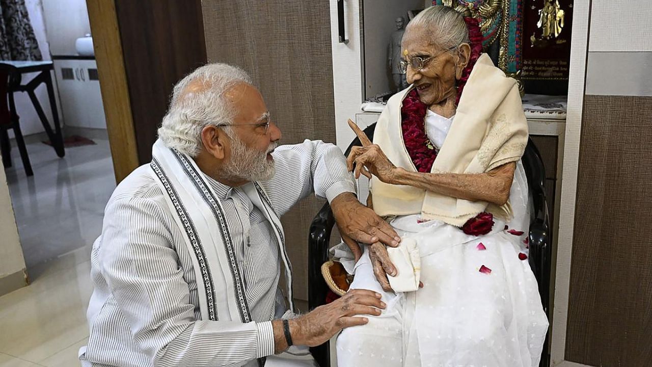 Prime Minister Narendra Modi (L) talking with his mother Hiraba Modi during a visit on the occasion of her 100th birthday in Gandhinagar. Credit: AFP Photo