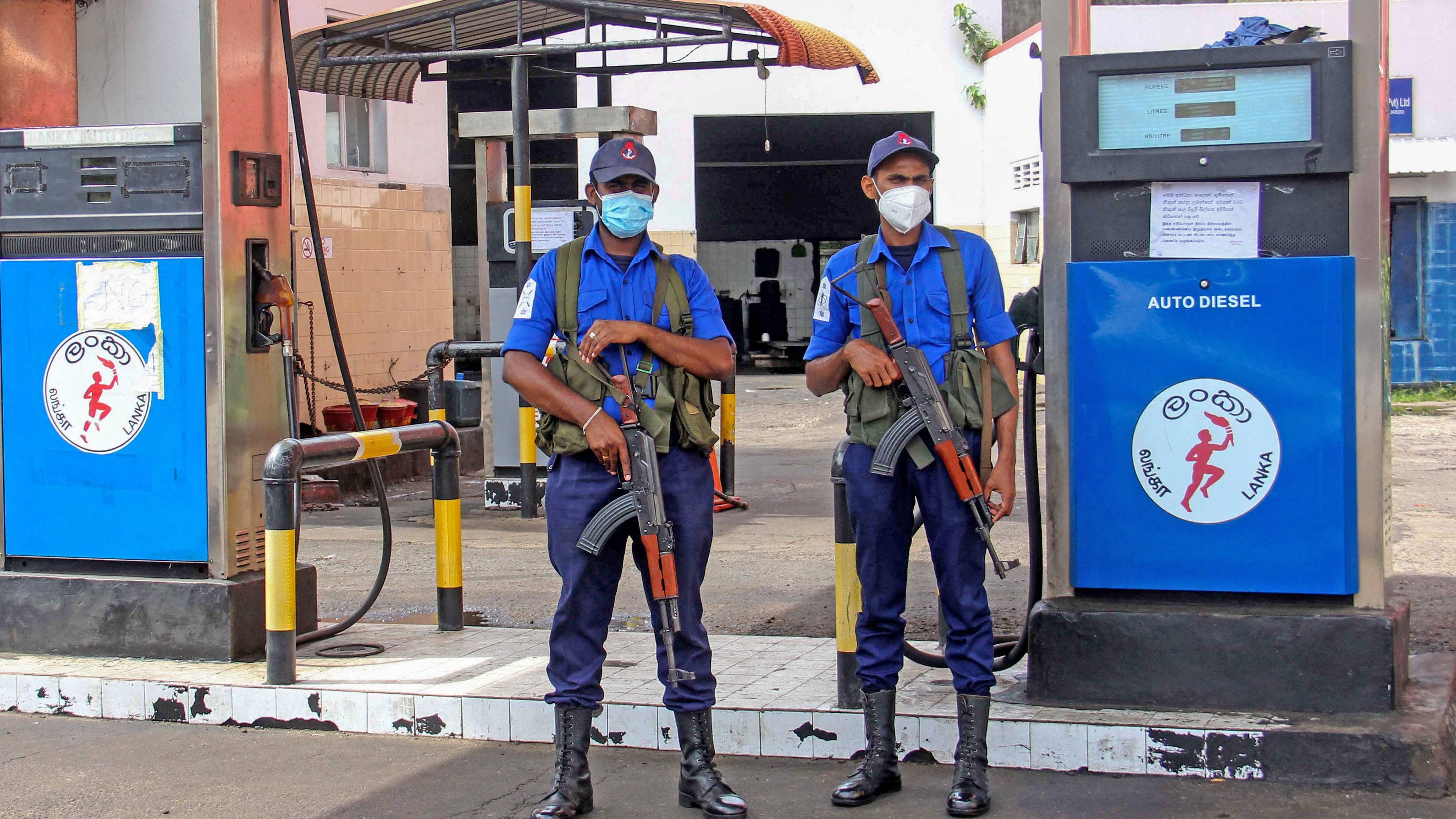 Navy officers stand guard at a closed fuel station in Colombo. Credit: AFP Photo