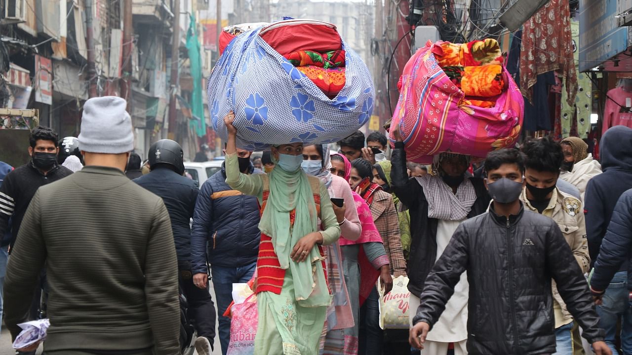People wearing face masks as a precaution against the coronavirus in a crowded market. Credit: PTI Photo