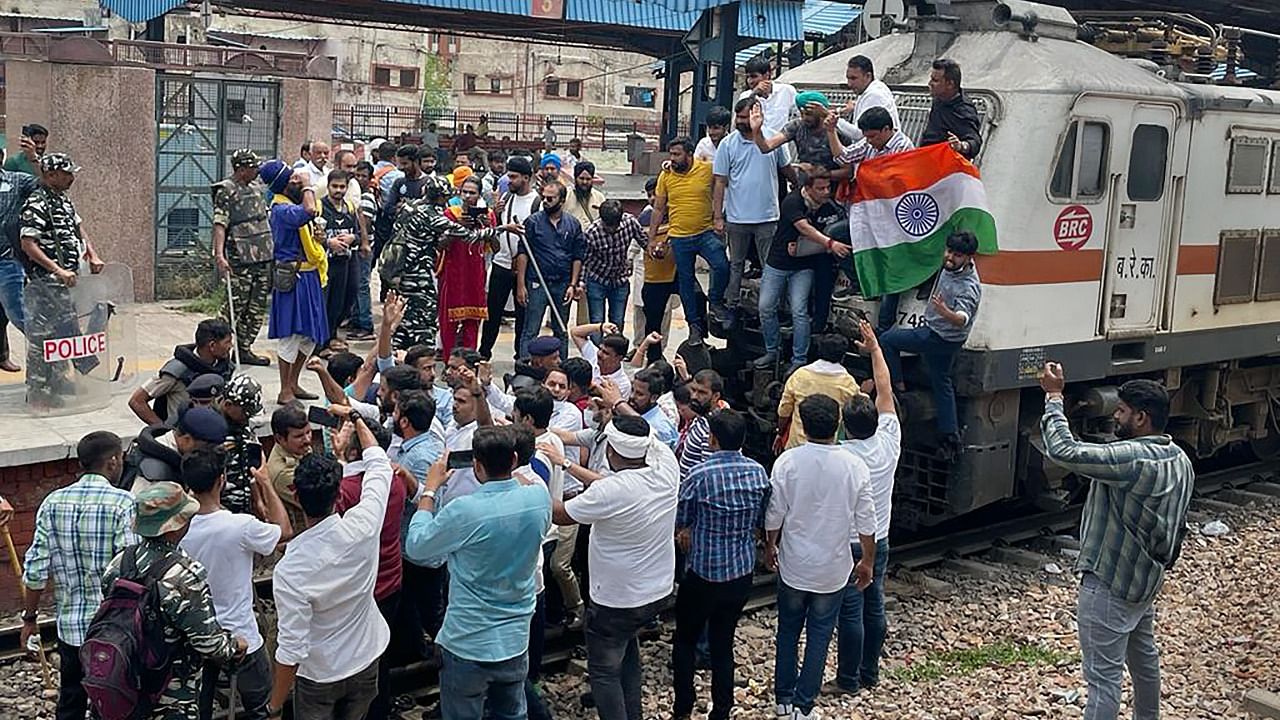 Members of Indian Youth Congress (IYC) stop a train at Shivaji Bridge as they protest over ED's probe against Rahul Gandhi in the National Herald case and Centre's 'Agnipath' scheme. Credit: PTI Photo