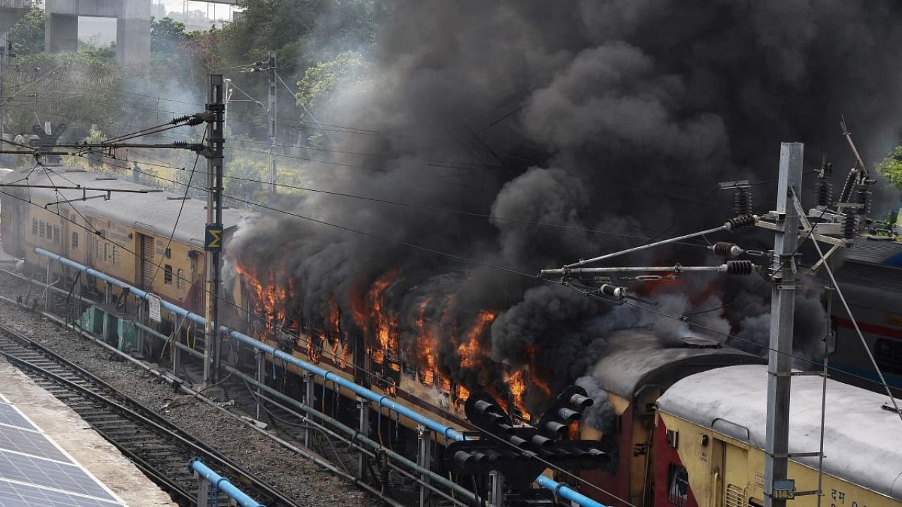 Smoke billows out from a passenger train coach after it was set on fire by protestors during a protest against "Agnipath scheme" for recruiting personnel for armed forces, in Secunderabad in the southern state of Telangana, India, June 17, 2022. Credit: Reuters Photo