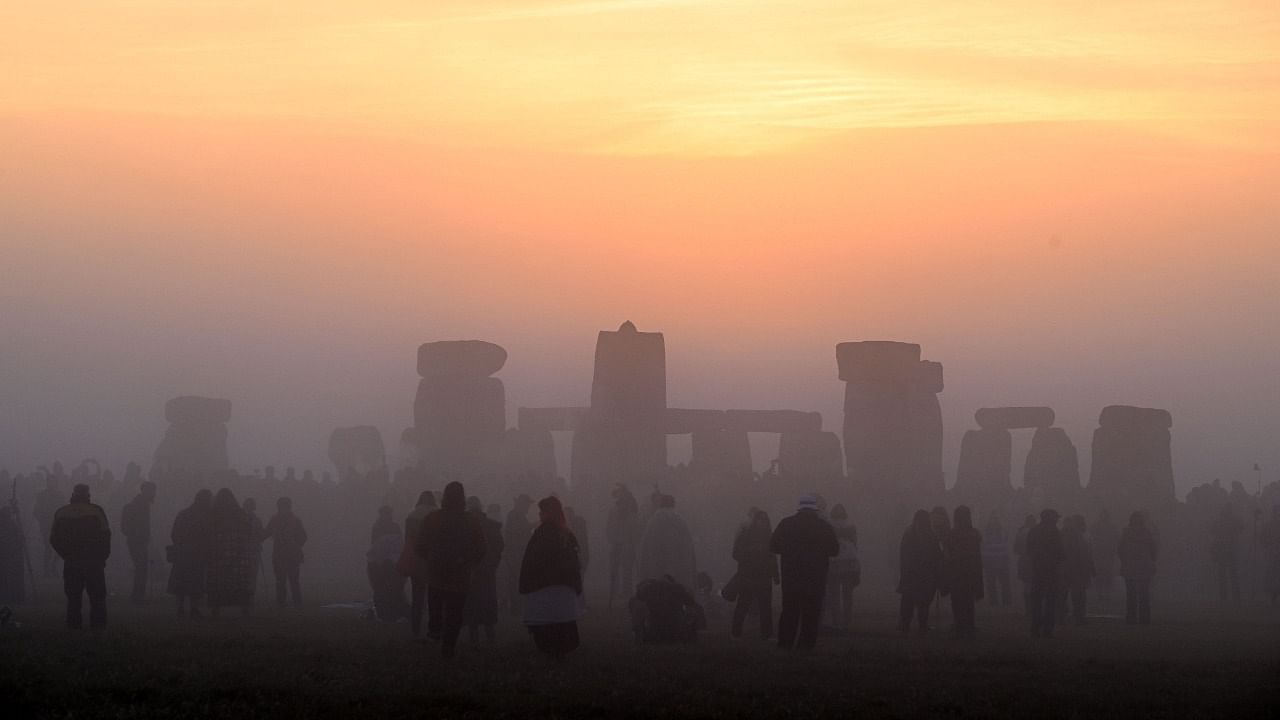 Revellers celebrate the Summer Solstice as the sun rises at Stonehenge. Credit: AFP Photo