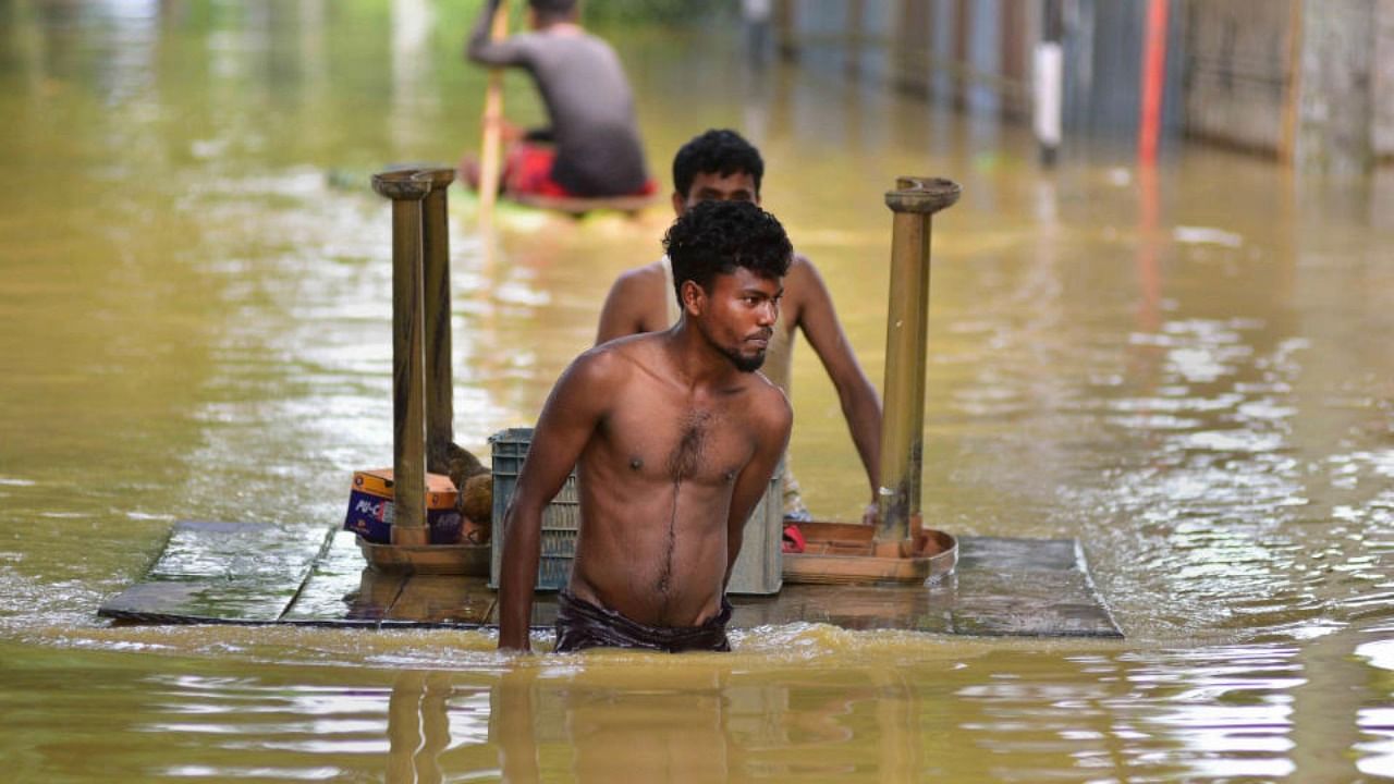  Villagers use a boat to commute at flood-hit at Raha village, in Nagaon district, Tuesday, June 21, 2022. Credit: PTI Photo