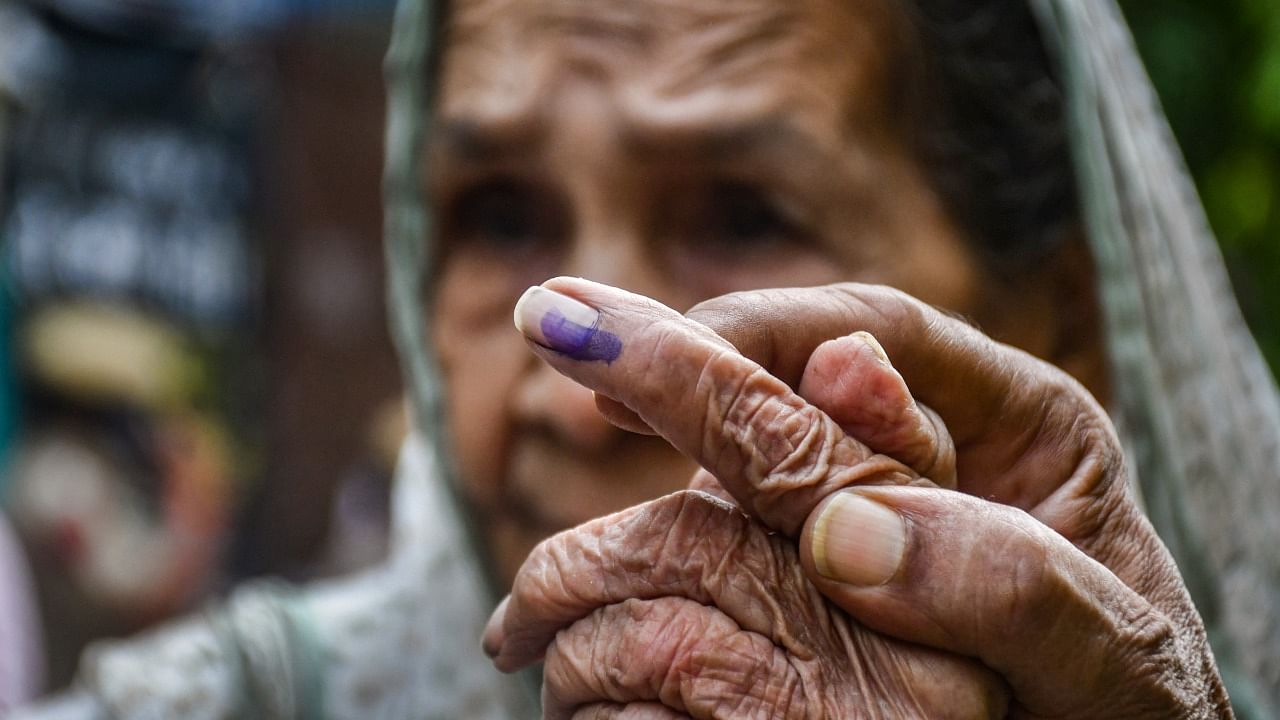 An elderly woman shows her inked finger as she comes out of a polling station after casting her vote for Rajinder Nagar Assembly bypoll. Credit: PTI Photo