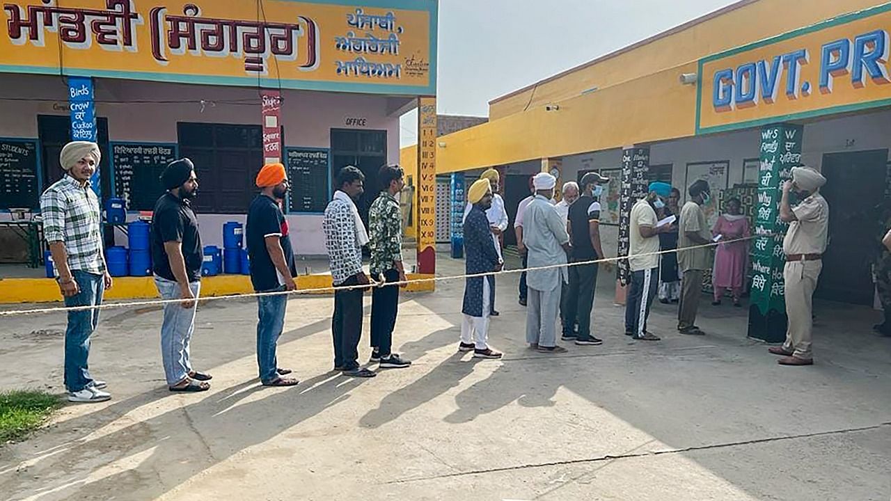 People queue up at a polling station to cast their votes for the Sangrur Lok Sabha bypolls, in Sangrur. Credit: PTI Photo