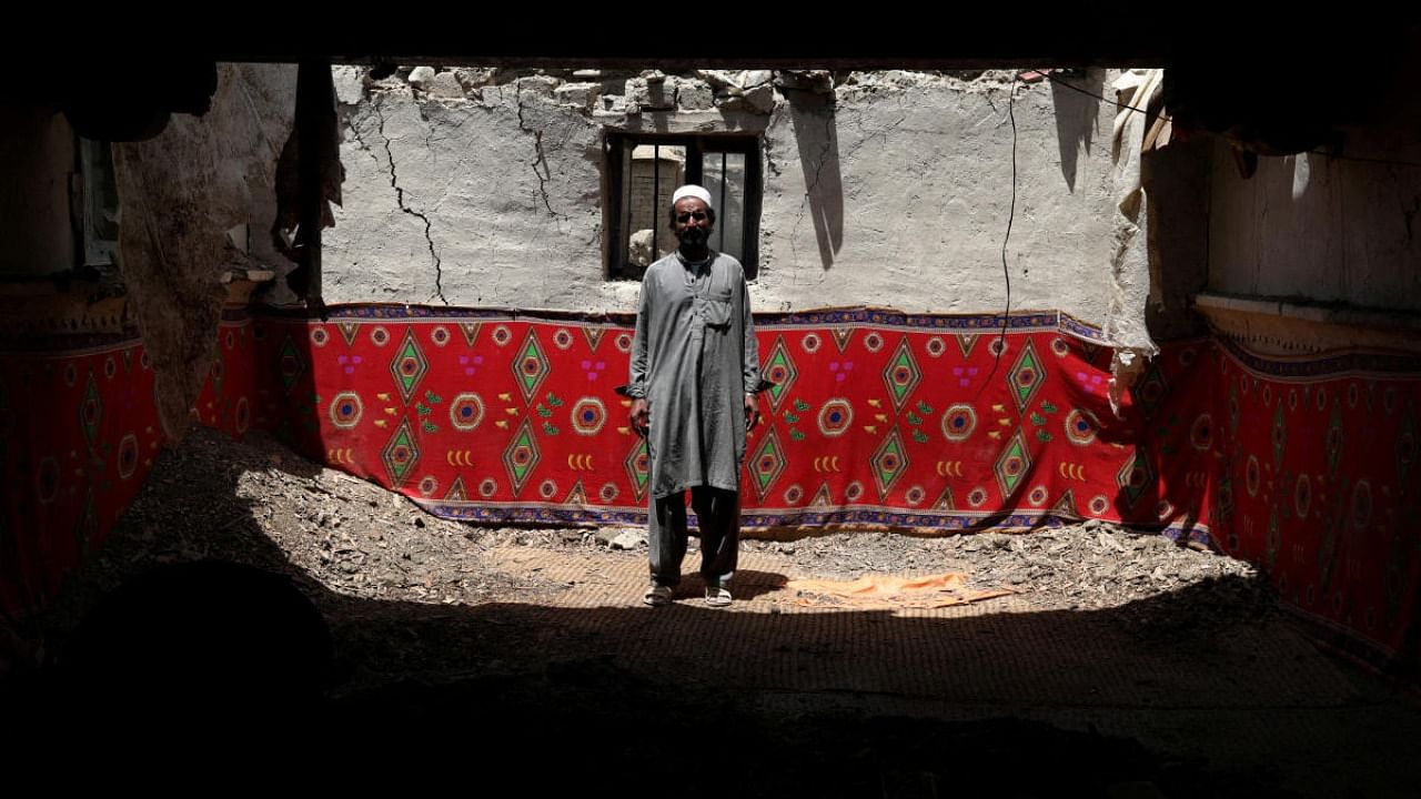 Ahmad Vali poses for a picture inside his house that was damaged by an earthquake in Gayan, Afghanistan, June 23, 2022. Credit: Reuters Photo