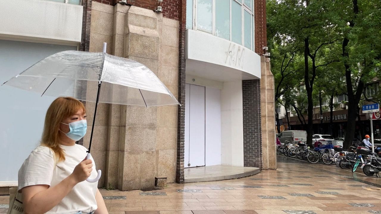 Woman walks past a closed H&M flagship store in Shanghai. Credit: Reuters Photo