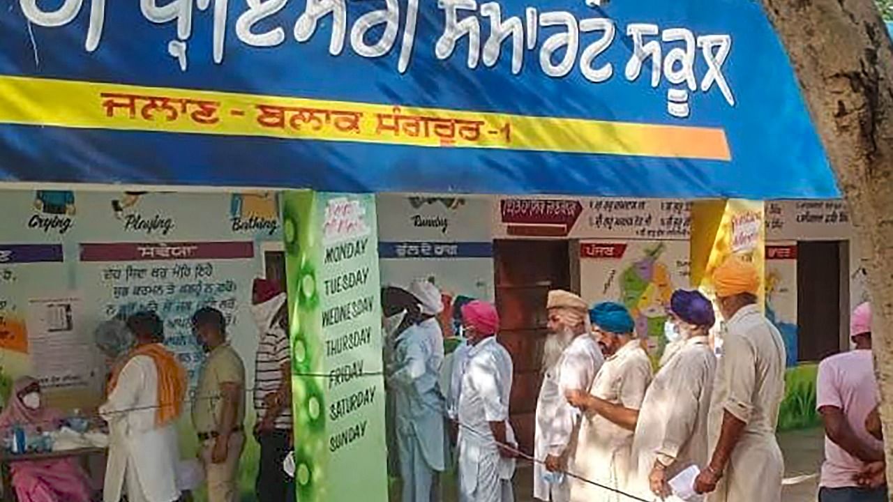 People queue up at a polling station to cast their votes for the Sangrur Lok Sabha bypolls, in Sangru. Credit: PTI Photo