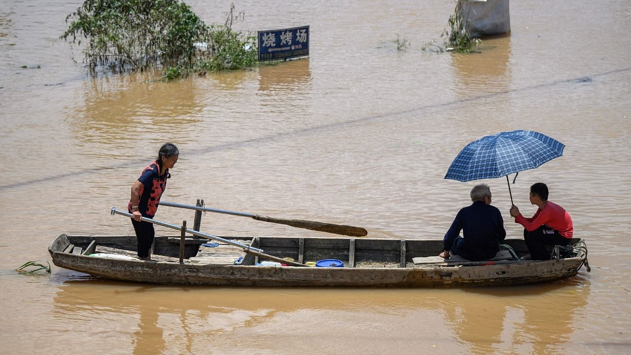 Residents ride a boat in a flooded area after heavy rains in Yingde, Qingyuan city, in China's southern Guangdong province on June 23, 2022. Credit: AFP Photo
