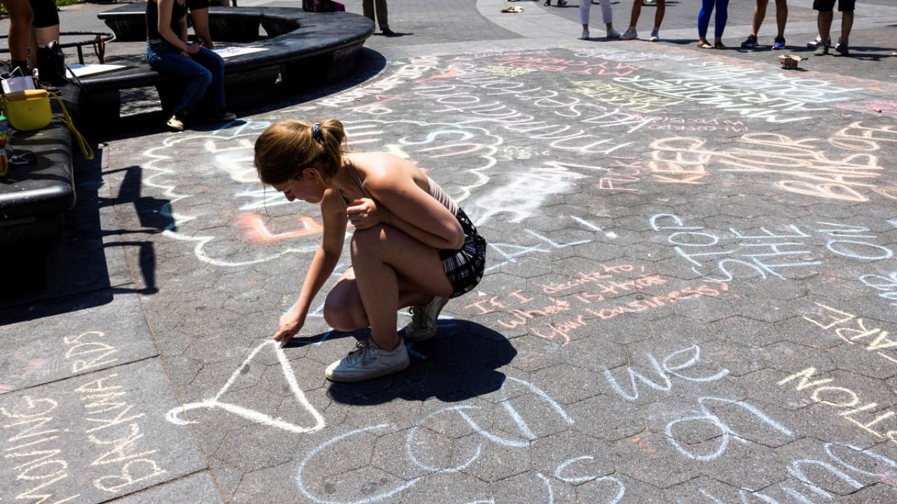 An abortion rights supporter writes on the ground at Washington Square Park in protest, after the United States Supreme Court ruled in the Dobbs v Women's Health Organization abortion case, overturning the landmark Roe v Wade. Credit: Reuters photo