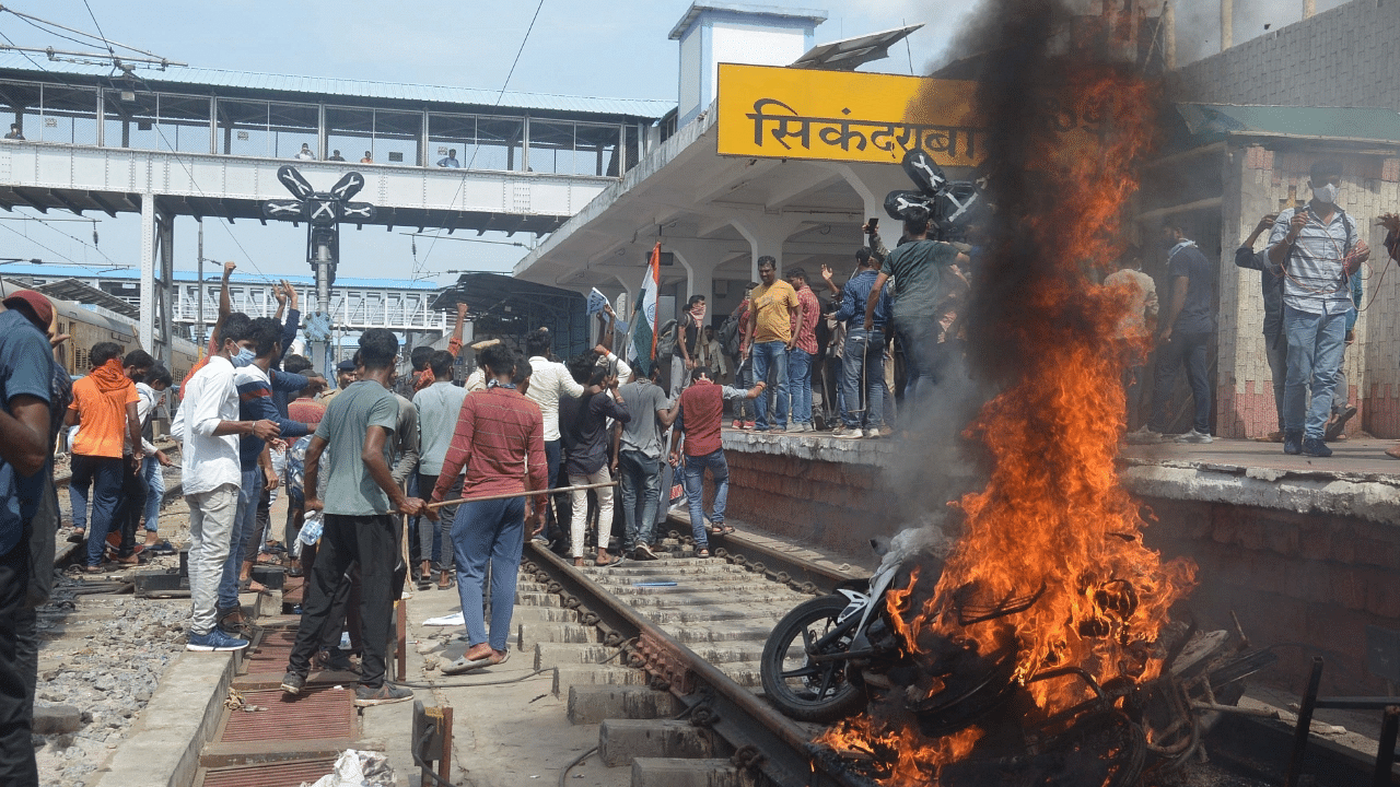 Protesters set ablaze a two-wheeler during a protest against Agnipath Recruitment Scheme, at Secunderabad railway station. Credit: IANS Photo