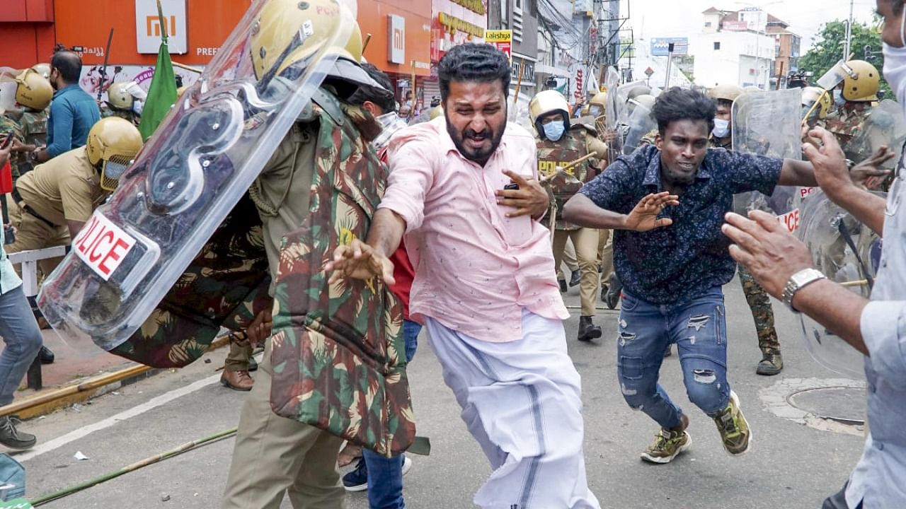 Security personnel chase away Youth Congress activists protesting outside the Kerala Secretariat, demanding the resignation of Kerala Chief Minister Pinarayi Vijayan over the Kerala gold smuggling case. Credit: PTI Photo
