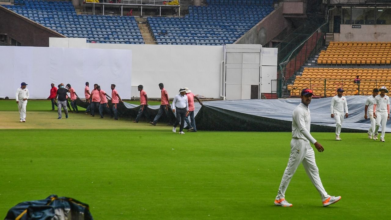 Cricket field staff covering the pitch due to rain at Madya Pradesh v/s Mumbai Ranji Trophy final. Credit: DH Photo