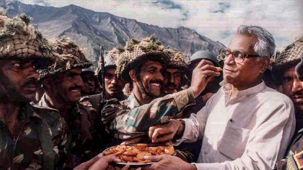 In this undated file photo the then defence minister George Fernandes shares snacks with the Army personnel during a visit to Ganasok in the Batalik Sector, J&K. Credit: PTI Photo