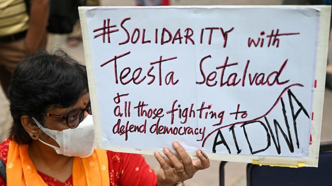A demonstrator holds a placard during a protest in New Delhi on June 27, 2022. Credit: AFP Photo