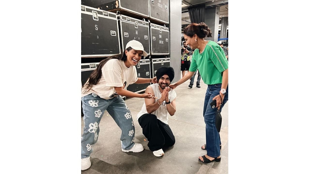Lilly, who was wearing a t-shirt printed with Diljit's face, shared another picture in which the singer had his head bowed down and his hands on her mom's feet. Credit: Instagram/@lilly