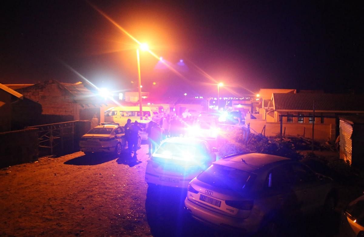 Police are seen outside a township pub in South Africa. Credit: AFP Photo