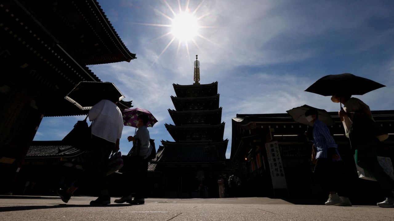 Visitors holding umbrellas stroll at Sensoji temple as Japanese government issues warning over possible power crunch due to a heatwave in Tokyo. Credit: Reuters photo