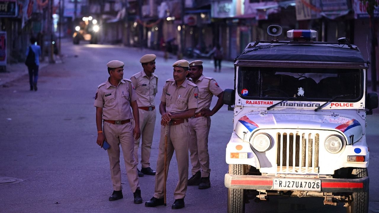 Police personnel stand guard along a deserted street during a curfew imposed by authorities following the killing of Hindu tailor Kanhaiya Lal. Credit: AFP Photo