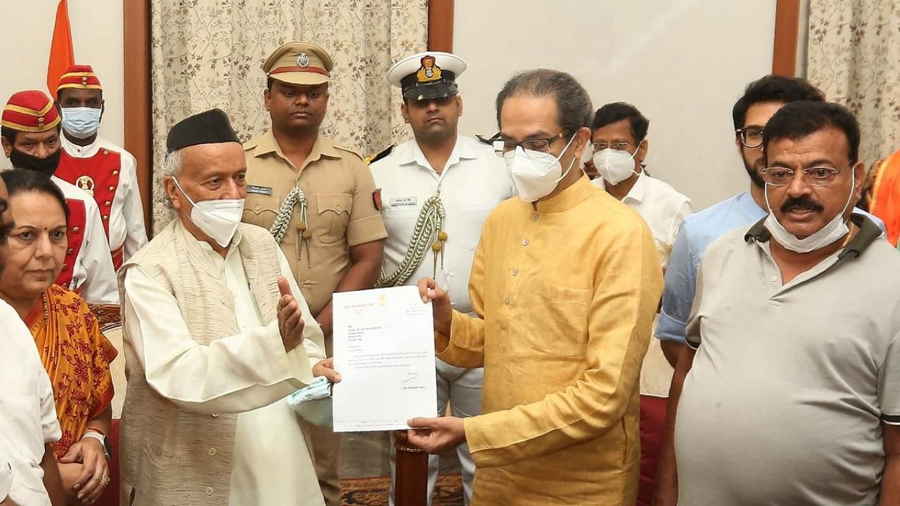 Governor of Maharashtra state Bhagat Singh Koshiyari (front 2L) receives the resignation letter of Chief Minister Uddhav Thackeray. Credit: AFP Photo/Governor House Mumbai