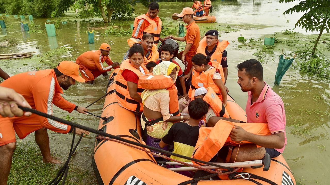 National Disaster Respond Force (NDRF) personnel rescue people from a flood-affected area, in Kamrup district. Credit: PTI Photo