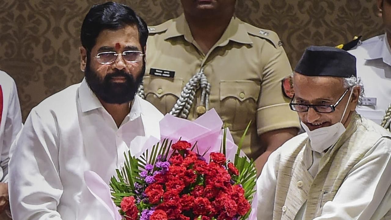 Newly elected Maharashtra Chief Minister Eknath Shinde being presented a bouquet by Governor Bhagat Singh Koshyari during his oath-taking ceremony, at Raj Bhavan in Mumbai, Thursday, June 30, 2022. Credit: PTI Photo