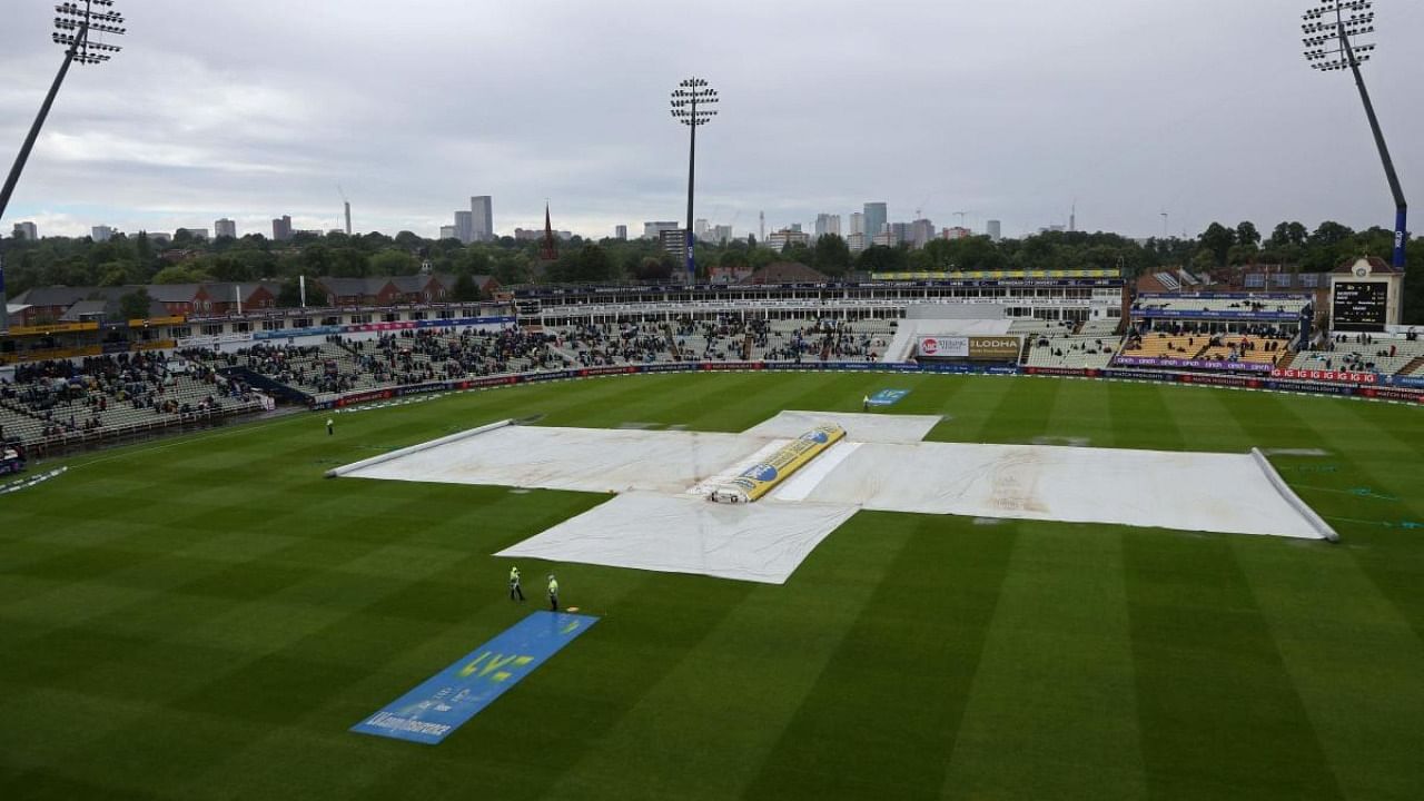 The covers protect the wicket as rain again prevents play from starting and an early tea is taken on Day 2 of the fifth cricket Test match between England and India at Edgbaston. Credit: AFP Photo