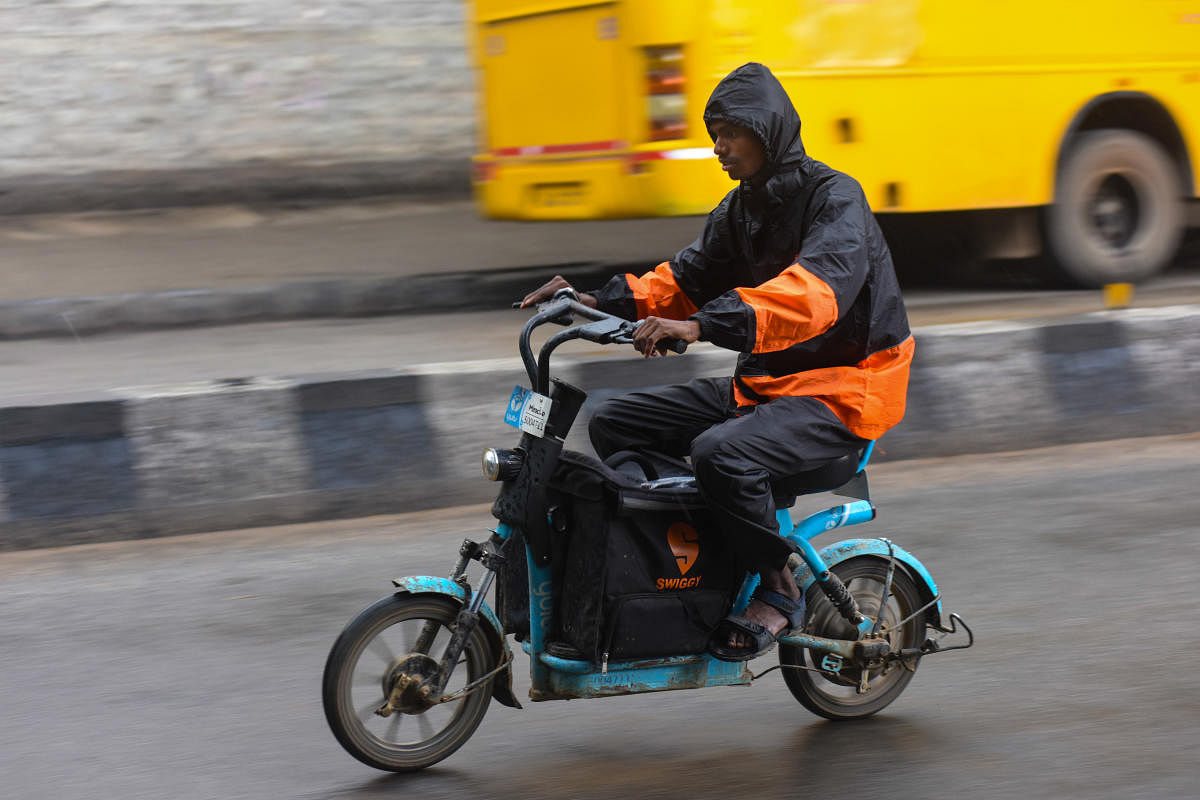 A gig workers rides during the rain in Bengaluru on Tuesday, May 17, 2022. DH PHOTO/PUSHKAR V