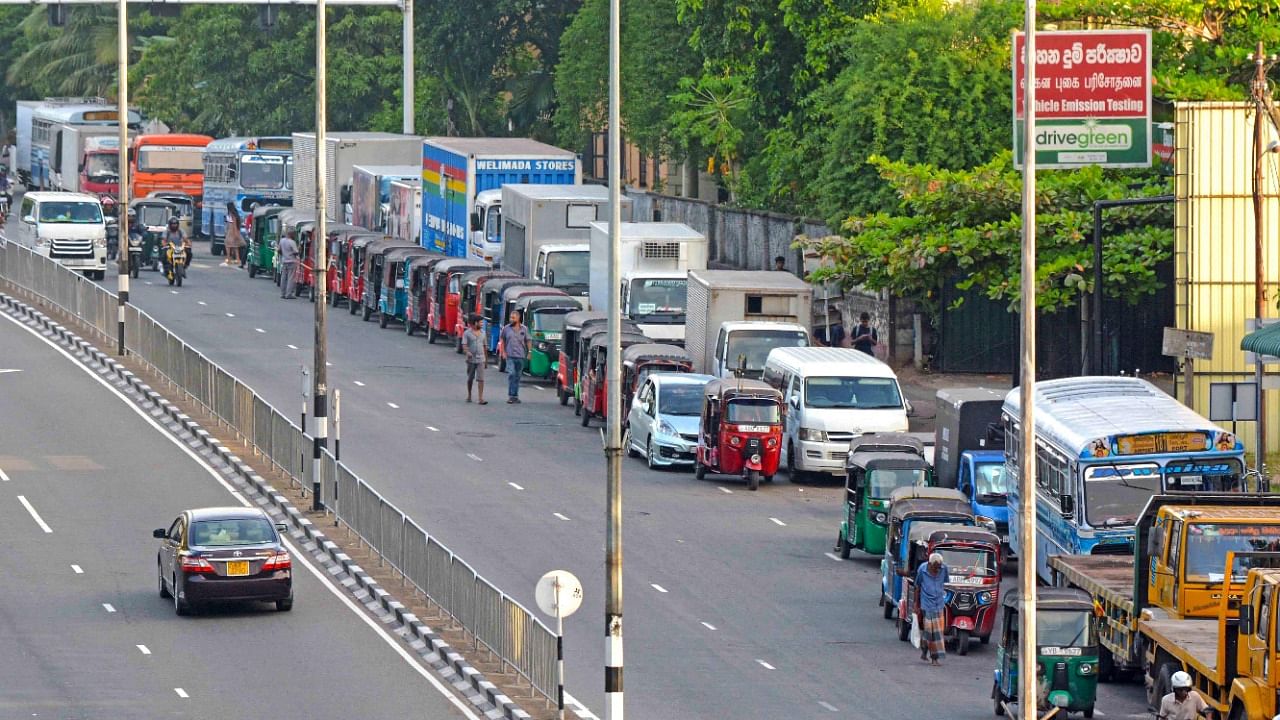 Motorists queue along a street to buy fuel at a fuel station in Colombo. Credit: AFP Photo