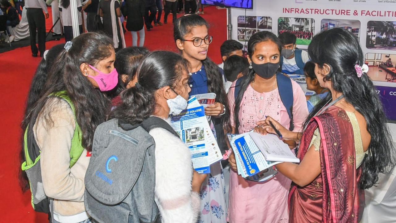 Students gather information on various courses at a stall at the education expo. Credit: DH Photo/ S K Dinesh