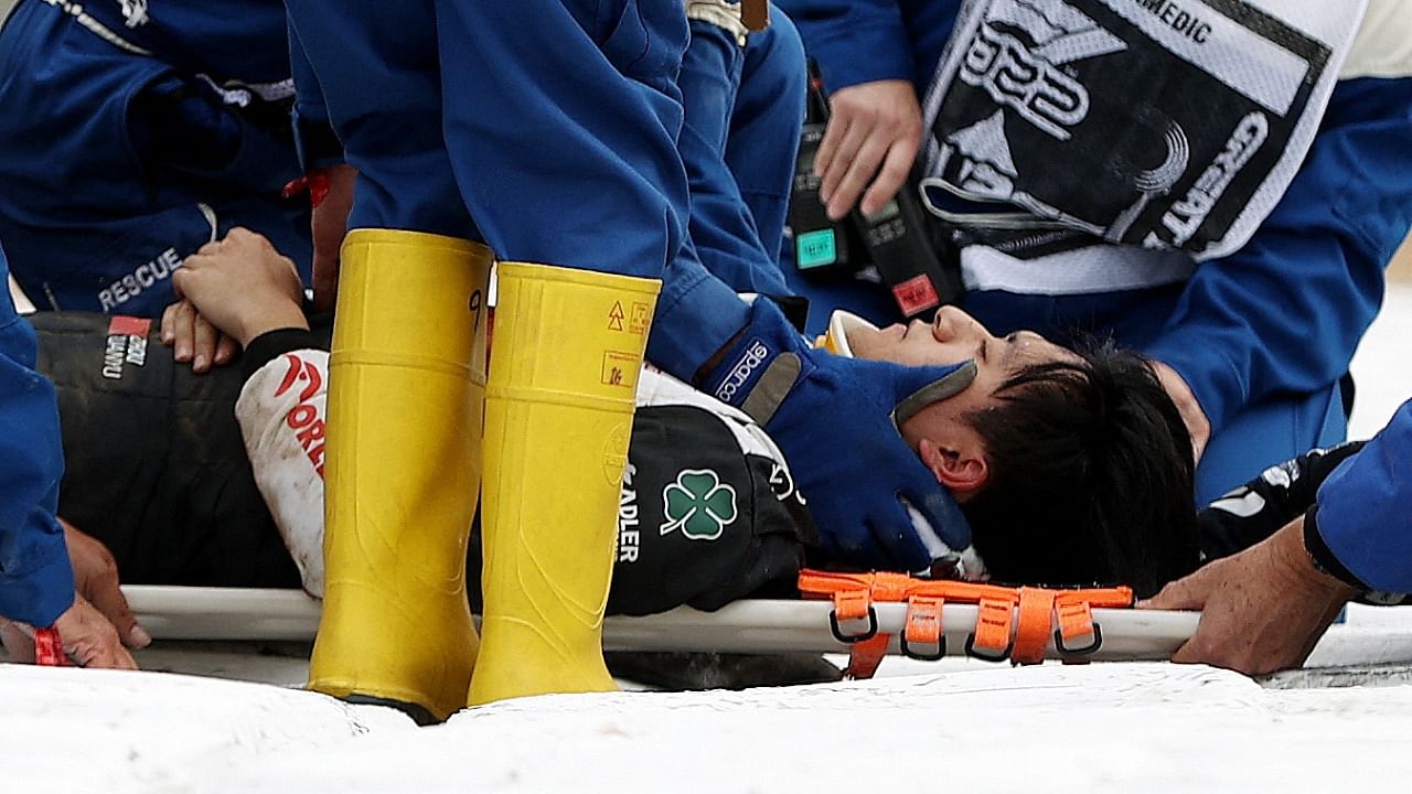 Alfa Romeo's Guanyu Zhou receives medical treatment after crashing out at the start of the race. Credit: Reuters Photo