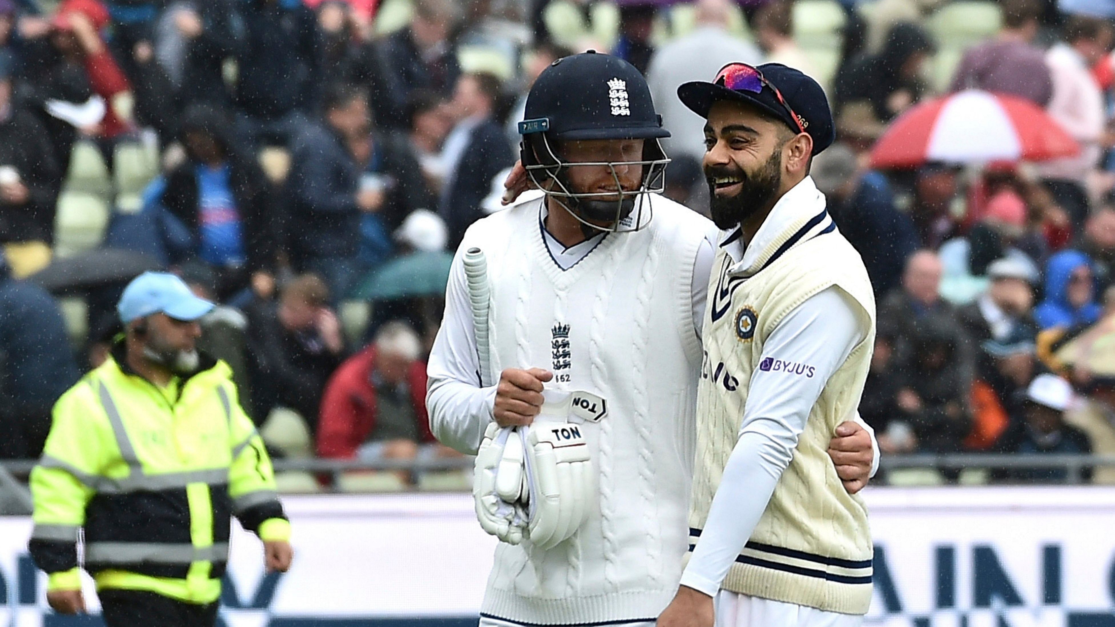 England's Jonny Bairstow and India's Virat Kohli, right, leave the pitch as rain stops play during the second day of the fifth cricket test match between England and India at Edgbaston. Credit: AP Photo