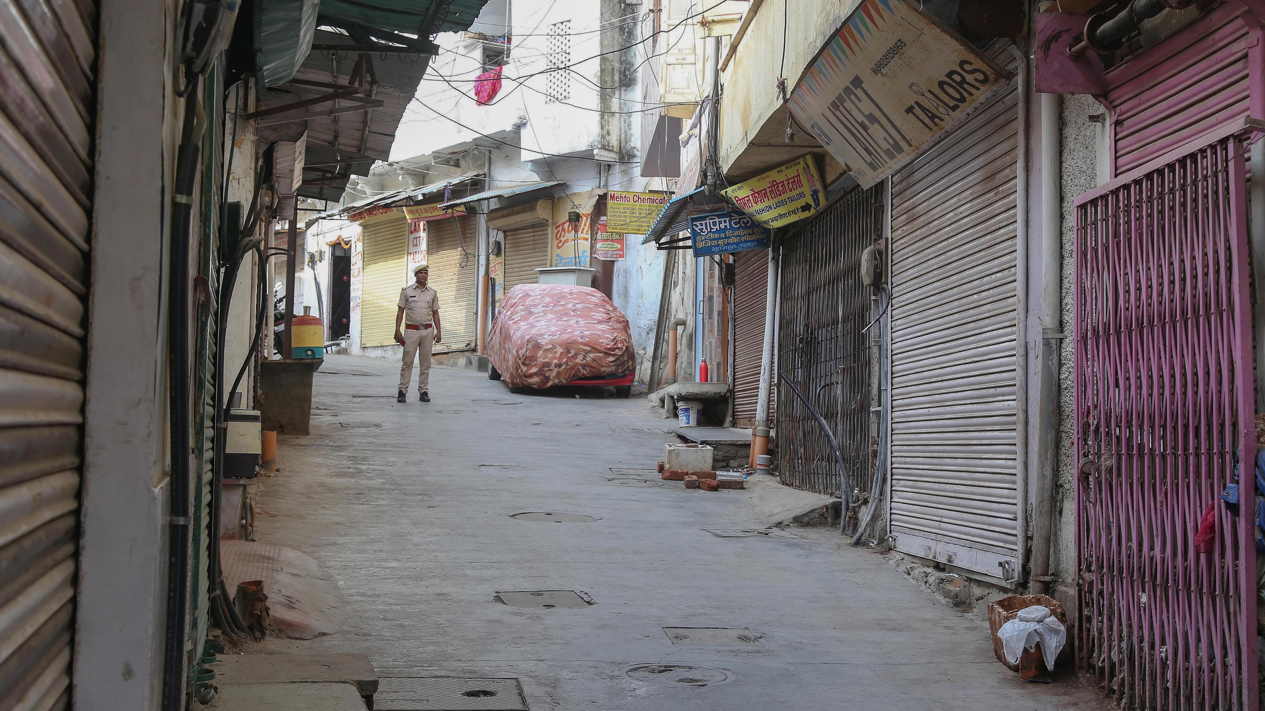 Security personnel stands guard outside the closed shop of tailor Kanhaiya Lal during a ten-hour relaxation in the curfew imposed by administration to maintain law and order after the latter's murder, in Udaipur. Credit: PTI File Photo