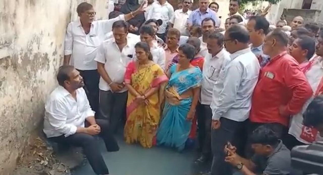 Andhra MLA Kotamreddy Sridhar Reddy enters drain in a novel protest. Credit: IANS Photo