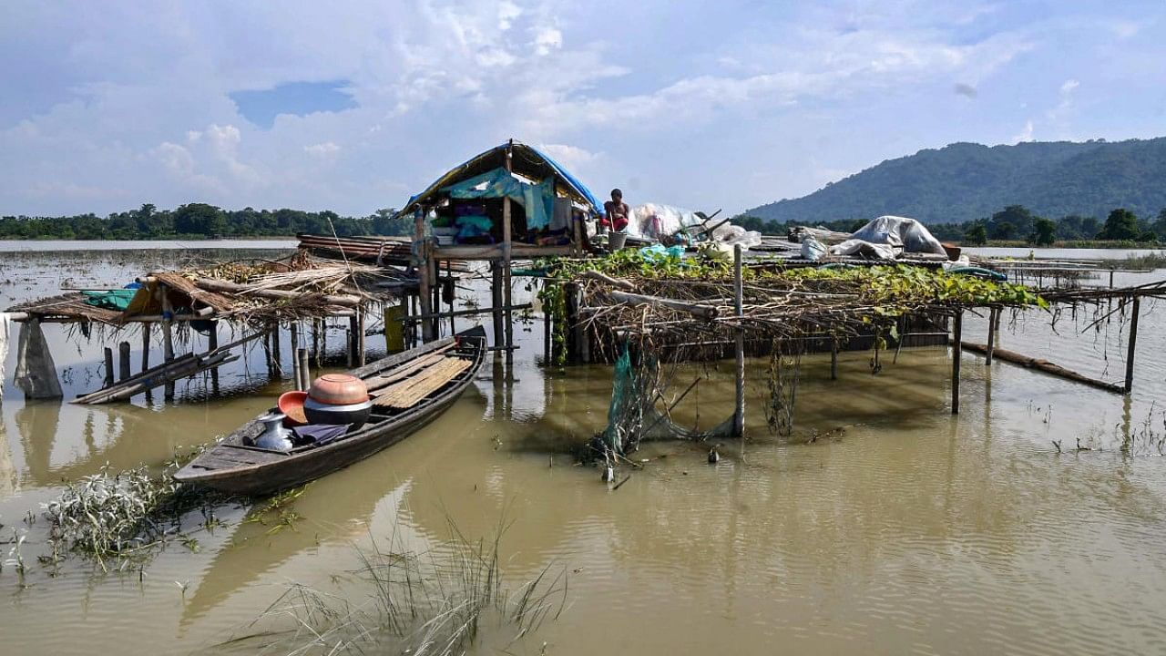 Villagers take shelter on a submerged house's rooftop, at the flood-affected Chanaka village, in Morigaon district. Credit: PTI File Photo