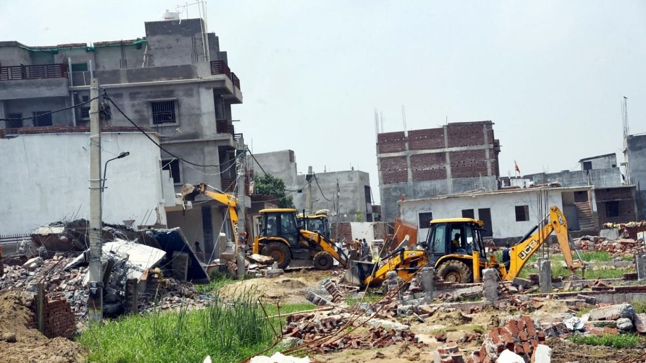 Bulldozers remove the illegal constructions during an anti-encroachment drive at Nepali Nagar in Patna on Monday, July 04, 2022. Credit: IANS Photo